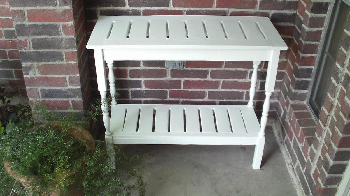 Outdoor console table with stair-baluster legs and a slatted top and shelf