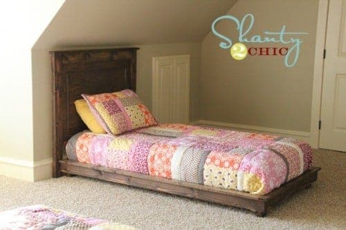 A low twin platform bed frame with a raised lip edge and tapered legs
