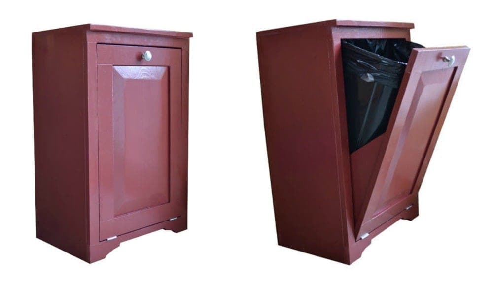 Wooden kitchen cabinet with front tilted open revealing a trash can
