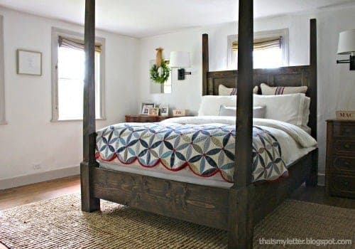 A queen canopy or poster bed built around turned pencil-post legs