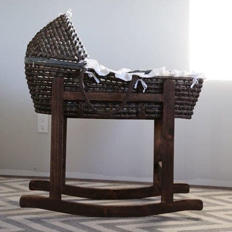 Wooden rocking stand cradling a Moses basket