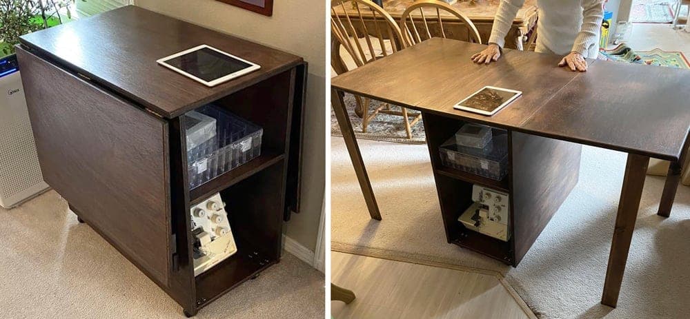 Rolling sewing cabinet with both hinged leaves raised into a long cutting table