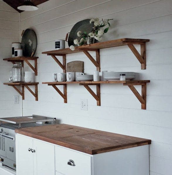 Rustic open kitchen shelving mounted on mitered wooden brackets