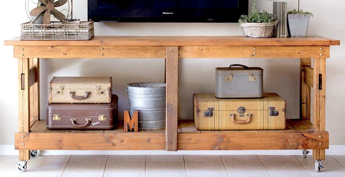 A long rolling console table with notched leg joinery styled after an industrial workbench