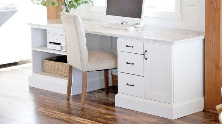 A built-in desk made from modular plywood cabinet bases with a countertop