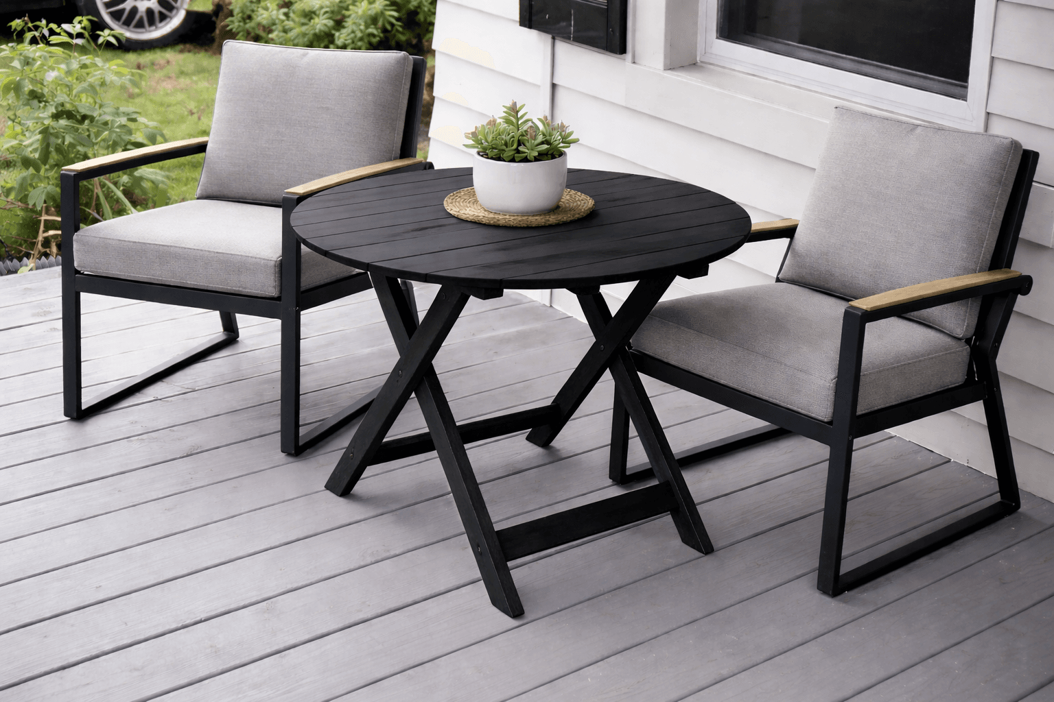 A round cedar outdoor side table with collapsible X-shaped leg supports
