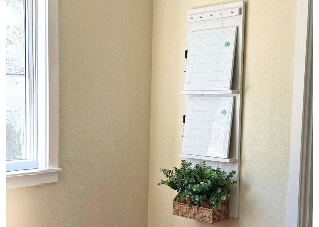 Wall-hung family command center with two calendars, ledge shelves, key hooks, and a mail basket