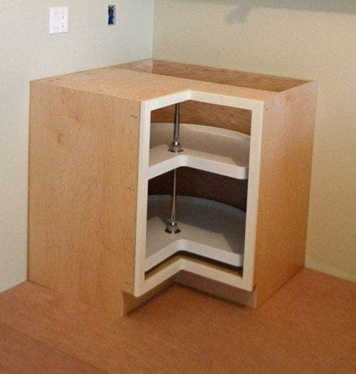 A corner kitchen base cabinet with an angled pie-cut door front