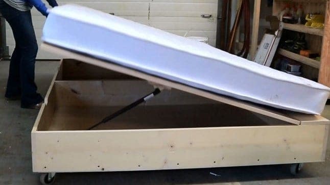 Storage bed with a hinged, spring-lifted top