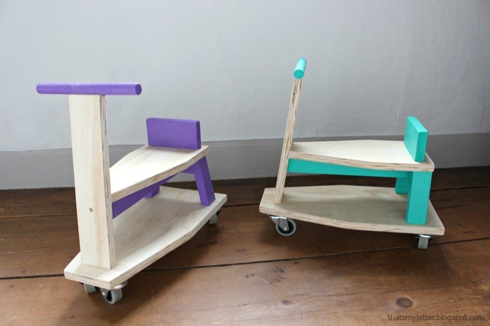 Small wooden toddler ride-on scooter with swivel casters and dowel handlebars