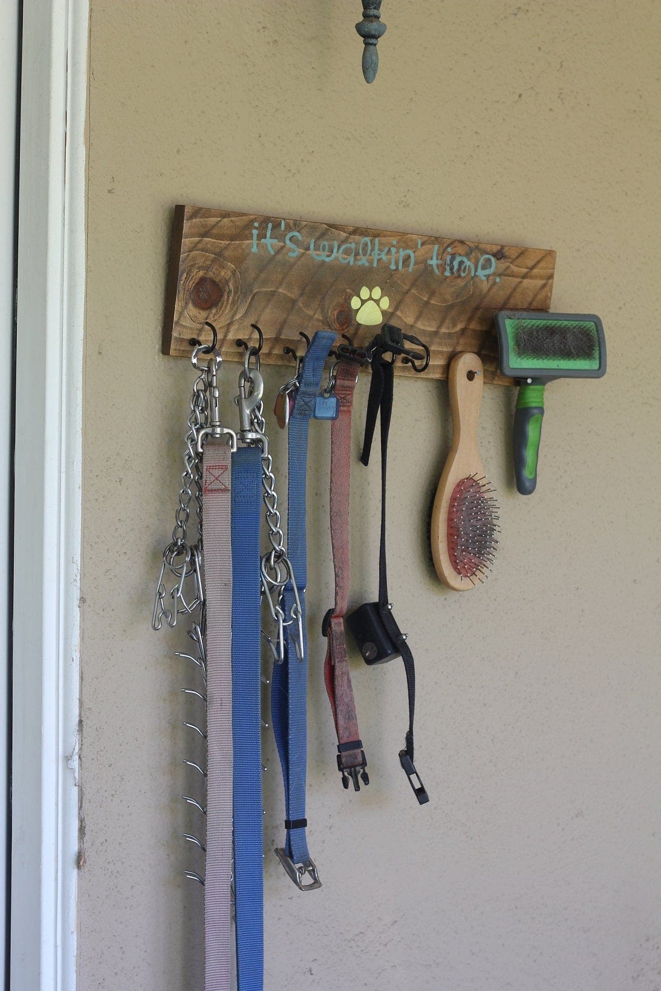 Wooden dog leash hanger with stenciled lettering and cup hooks